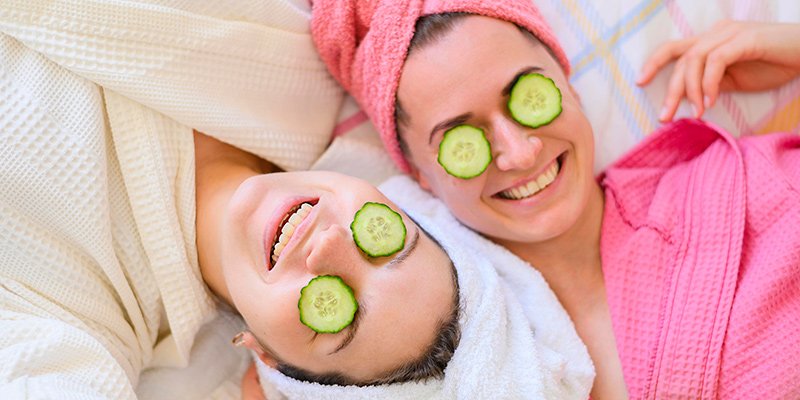 Women relaxing with cucumber on eyes